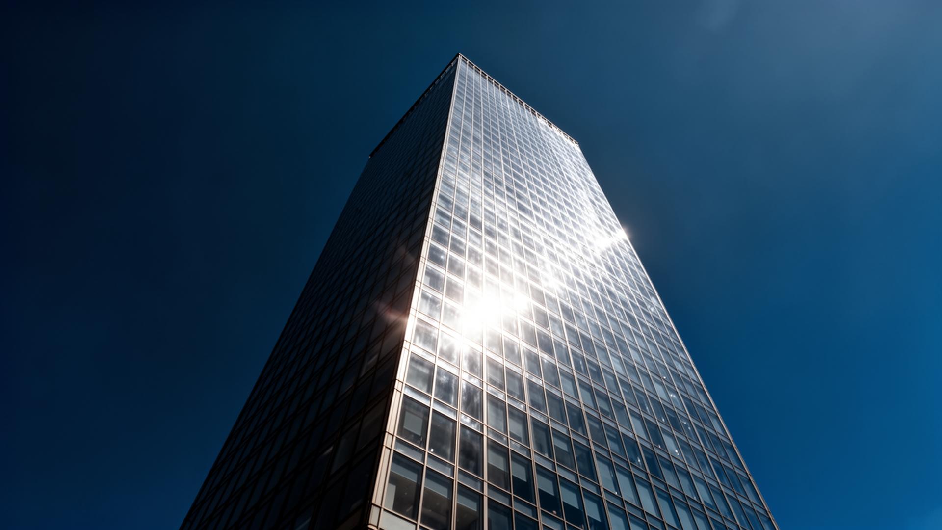 Glass skyscraper reaching into a deep blue sky